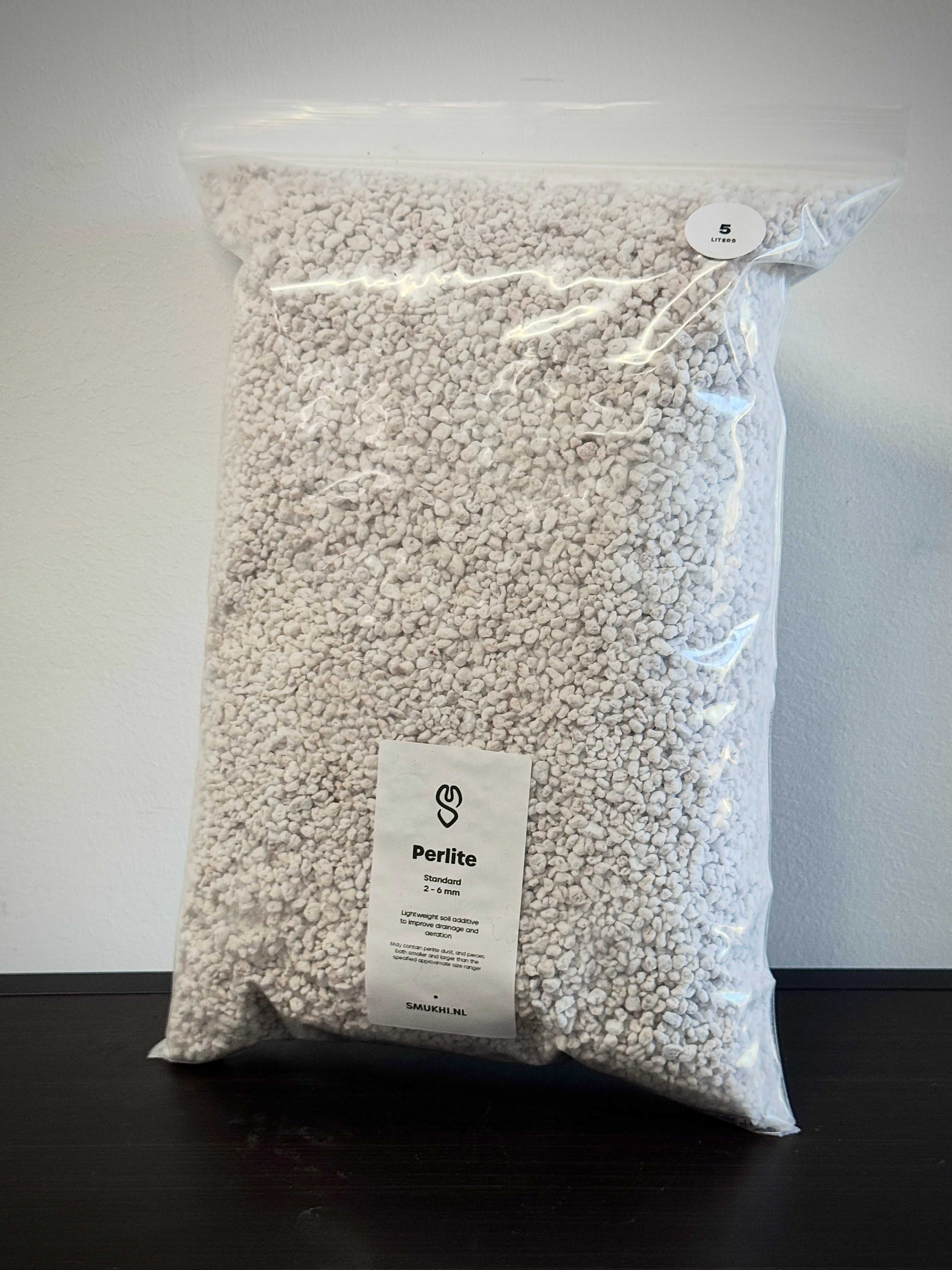 SMUKHI perlite substrate shown in a close-up, light and porous volcanic mineral used for soil aeration and plant growth.