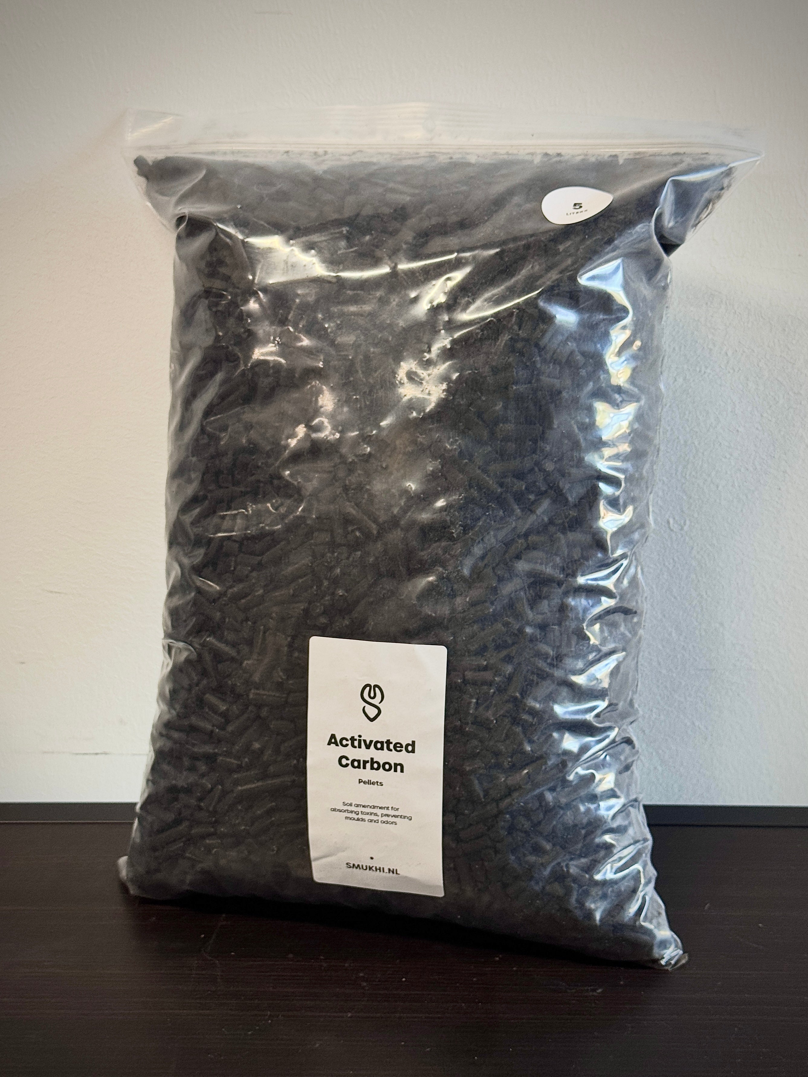 SMUKHI activated carbon substrate for aquariums, showing black porous material used for filtration and water purification.