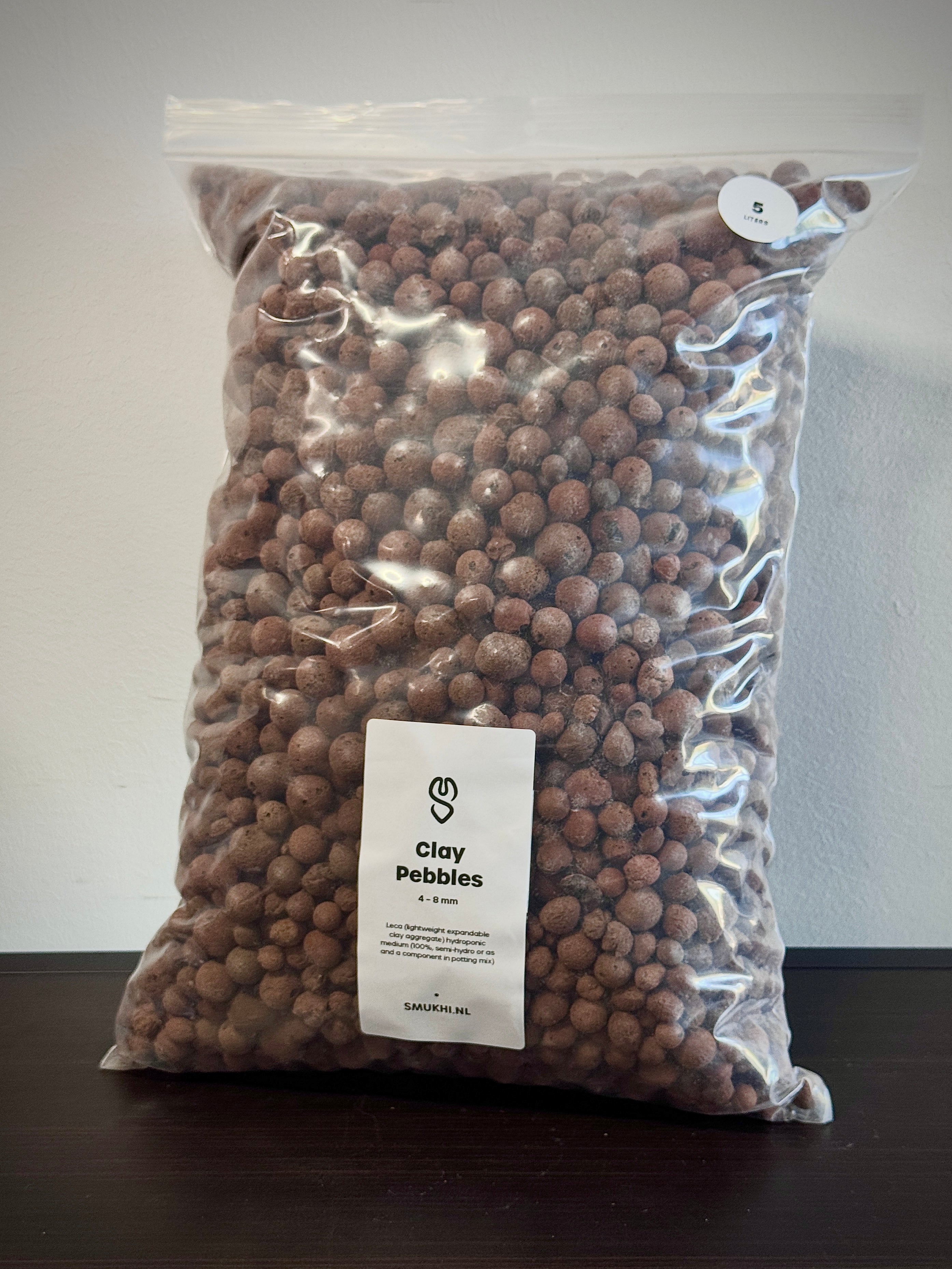 SMUKHI clay pebbles substrate with smooth, rounded clay balls for plant drainage and hydroponic systems.
